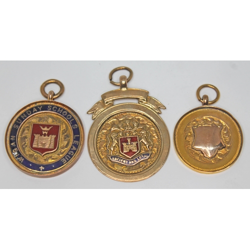 217 - A group of three hallmarked 9ct gold fob medals, gross wt. 14.03g.