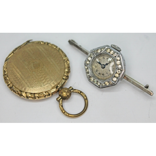 242 - A 1920s silver cocktail watch brooch and a 19th century yellow metal locket.