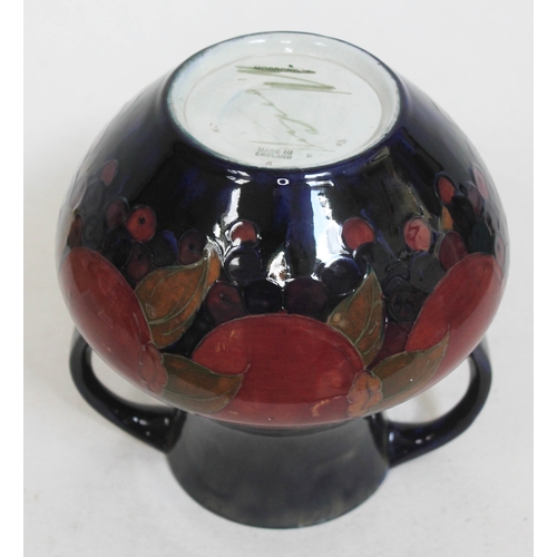 423 - A Moorcroft pottery twin handle vase decorated in pomegranate, height 21cm.