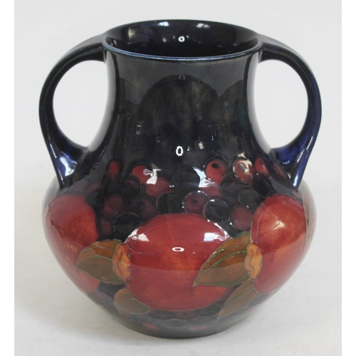 423 - A Moorcroft pottery twin handle vase decorated in pomegranate, height 21cm.