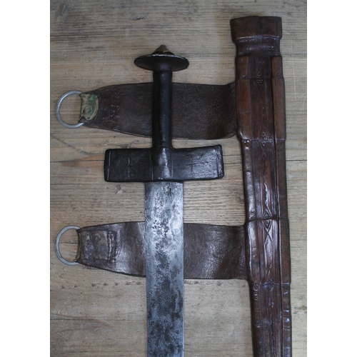 444 - A North Aarican takouba sword and leather scabbard, blade length 70cm, total length 89cm.