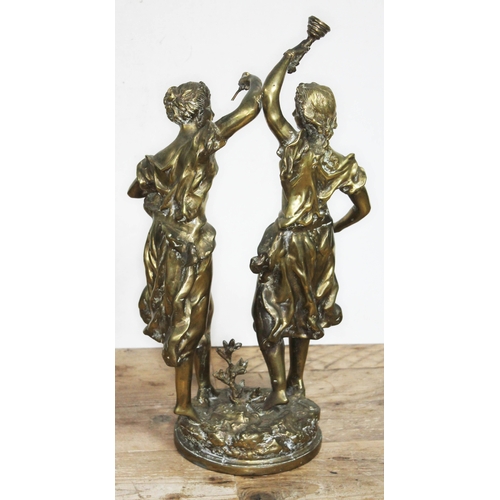 318 - A bronze figure depicting two women dancing, one holding a torch, indistinctly signed, height 49cm.