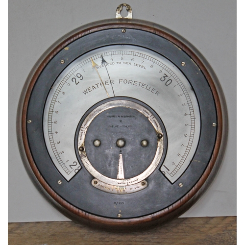 79 - A circular oak cased Weather Foreteller by Negretti & Zambra, diam. 26cm.