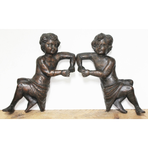 80 - A pair of carved flat back wooden figures, each resting on one elbow and wearing a cloth around wais... 