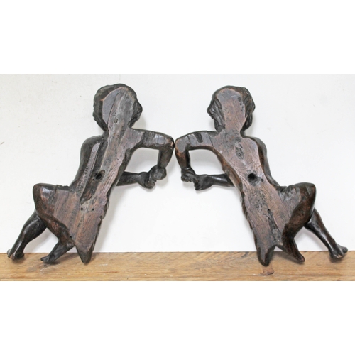 80 - A pair of carved flat back wooden figures, each resting on one elbow and wearing a cloth around wais... 