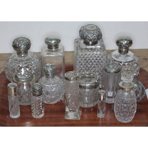 91 - A group of fourteen hallmarked silver topped or mounted glass bottles and jars, tallest 14cm.