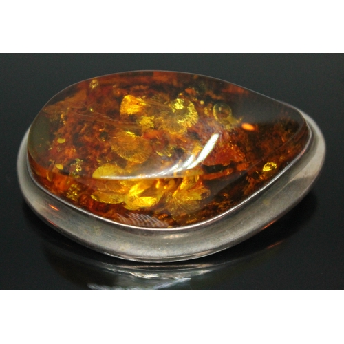 133 - A Modernist amber brooch of abstract form, marked 925, length 46mm.