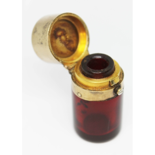 167 - A Victorian silver gilt mounted cranberry glass scent bottle, the interior lid with sprung glass sto... 