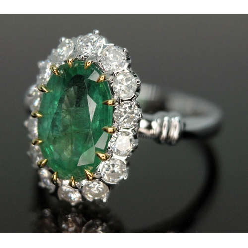 195 - An emerald and diamond ring, the central oval cut and claw emerald approx. 2.40ct, surrounded by fou... 