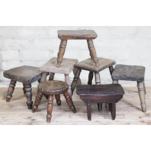 57 - A group of seven wooden milking stools, heights ranging from 18cm to 26cm.