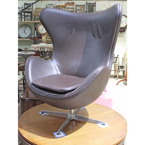 67 - A brown leather egg chair in the manner of Arne Jacobsen for Fritz Hansen.