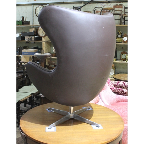 67 - A brown leather egg chair in the manner of Arne Jacobsen for Fritz Hansen.