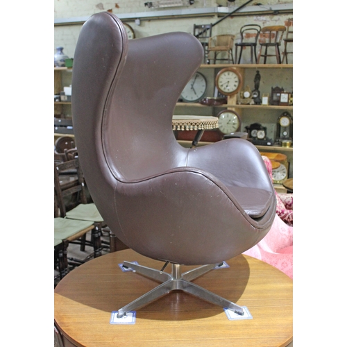 67 - A brown leather egg chair in the manner of Arne Jacobsen for Fritz Hansen.