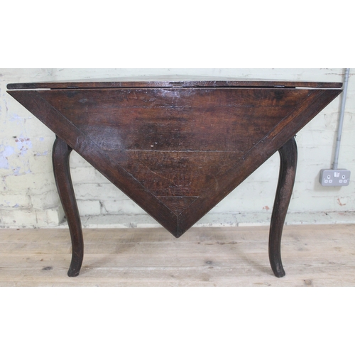 73 - An early 18th century oak gate leg table of triangular form with single drop leaf forming a square, ... 