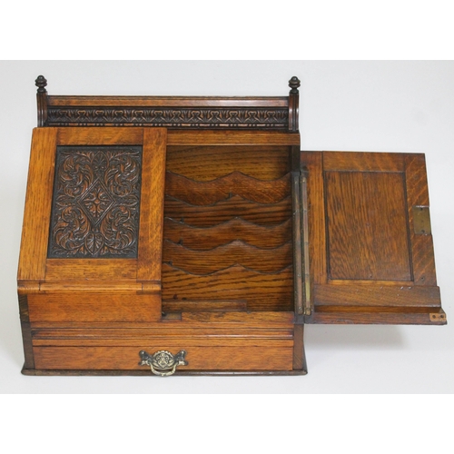 86 - A Victorian oak stationary box with carved panelled doors and lower drawer, height 36cm.