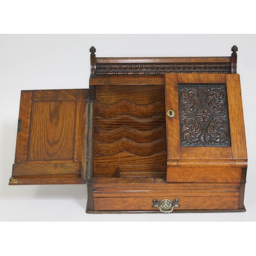 86 - A Victorian oak stationary box with carved panelled doors and lower drawer, height 36cm.