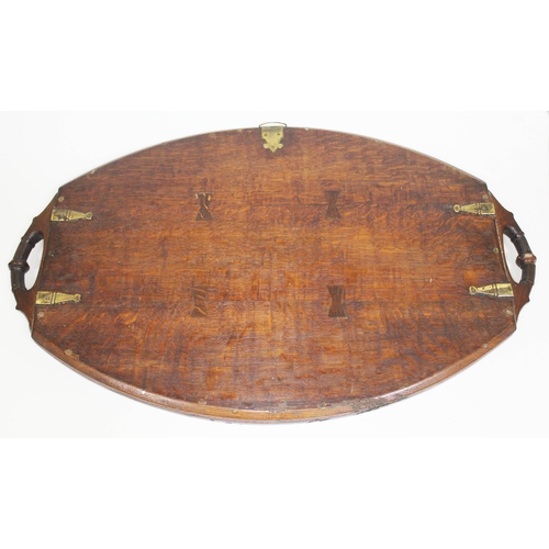 88 - A late Victorian brass inlaid oak tray of oval form with carved handles, length 72cm.