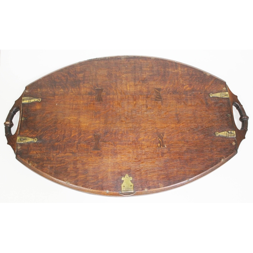 88 - A late Victorian brass inlaid oak tray of oval form with carved handles, length 72cm.