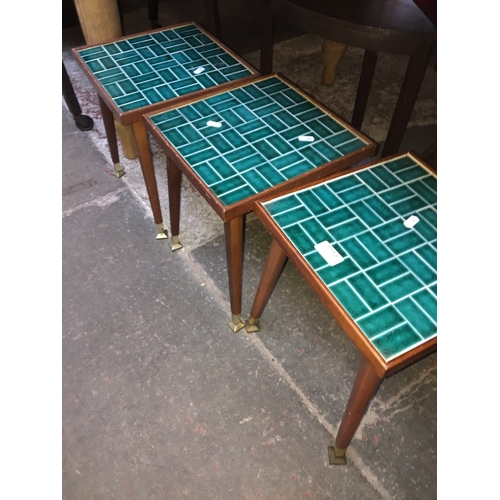 913 - A set of three retro tile top small tables on tapered legs