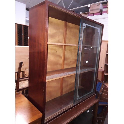 892 - A bookcase with glass sliding doors.