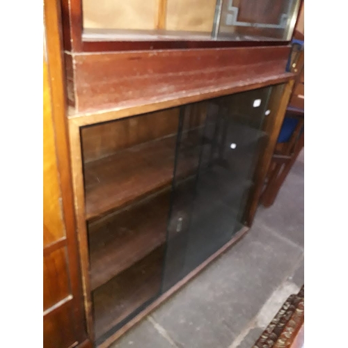 893 - A bookcase with glass sliding doors.