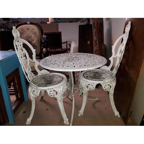 923 - A white painted cast metal table and two chairs.