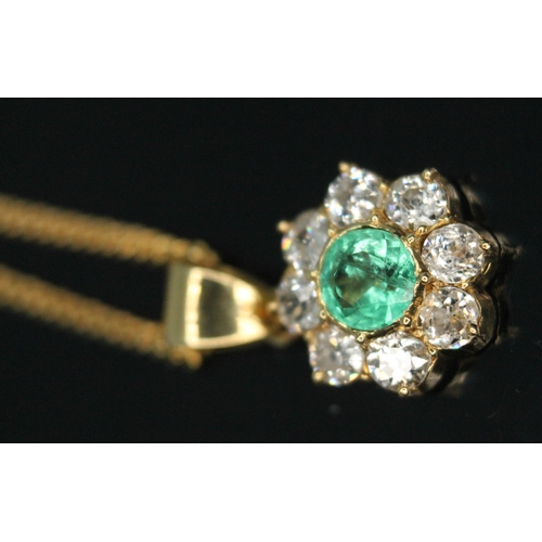 110 - A diamond and emerald cluster pendant, the central bezel set old European cut emerald weighing appro... 