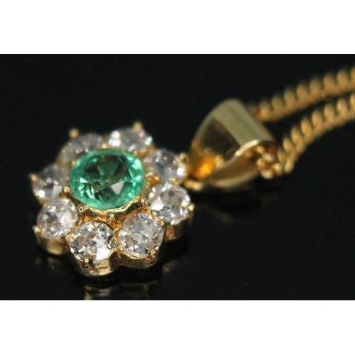 110 - A diamond and emerald cluster pendant, the central bezel set old European cut emerald weighing appro... 