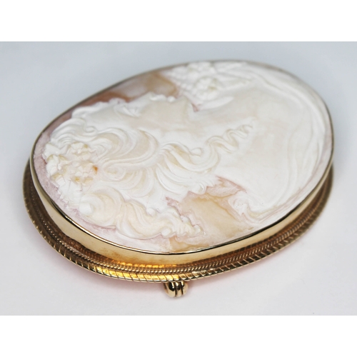 120 - A hallmarked 9ct gold mounted shell cameo brooch of oval form and carved with a pre-raphaelite style... 