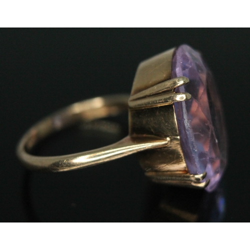 128 - A ring set with purple paste, marked 9ct, gross wt. 5.93g, size M.