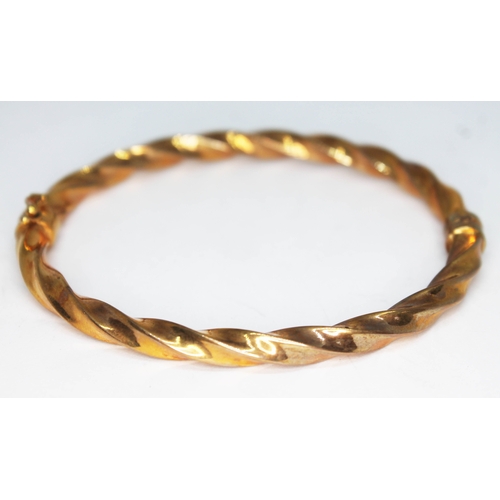 131 - A bangle of twist form, 9ct gold import marks, diam. 6cm, wt. 6.13g.