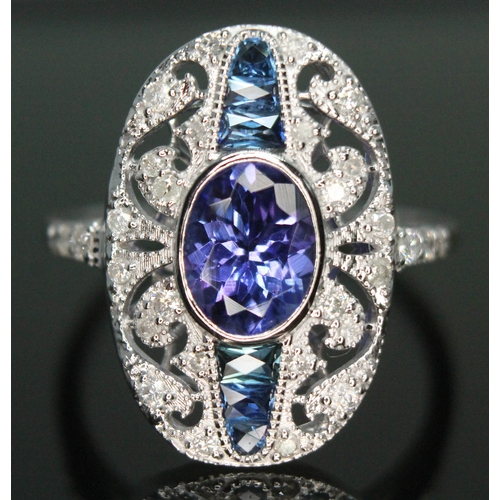 141 - A tanzanite, sapphire and diamond cluster ring, the central oval cut and bezel set tanzanite approx.... 