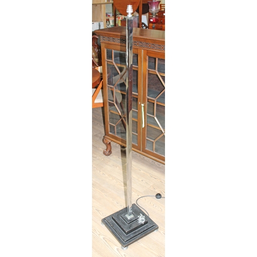 44 - An Art Deco chrome floor lamp with square column on four stepped wooden base having applied chrome l... 