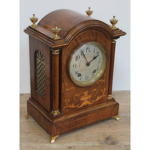 68 - An Edwardian walnut mantle clock with domed top, brass finials, marquetry inlay, columns, fish grill... 