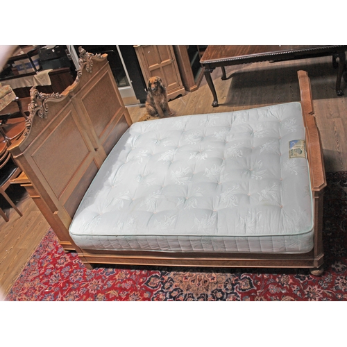 85 - A continental birds eye maple double bed circa 1900, the heads with carved scrolls, with super king ... 