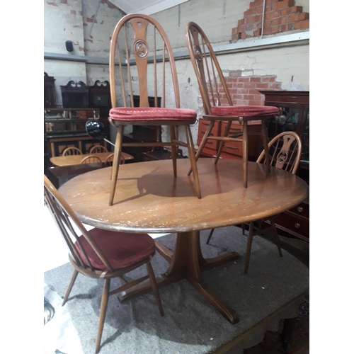 82 - An Ercol table and four swan back chairs.