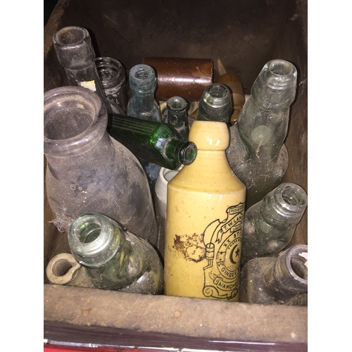 237 - An old wooden box containing various old bottles.