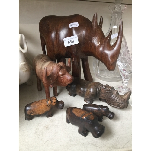 559 - A group of African hand carved wooden animals, including rhino, buffalo and hippopotamus.