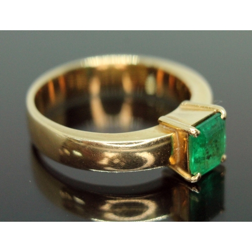 134 - A emerald ring, the rectangular emerald cut emerald weighing approx. 0.73 carats, the band marked '1... 