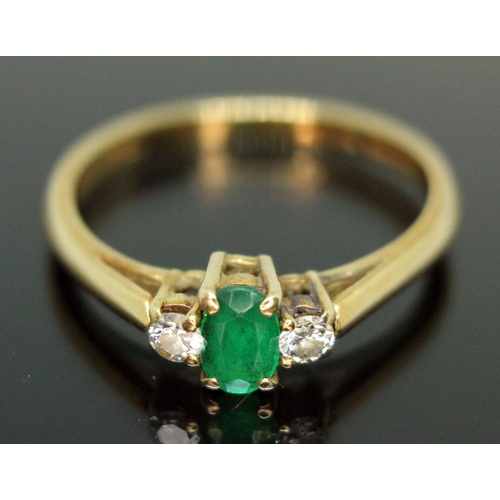 138 - An emerald and diamond ring, the central oval cut emerald measuring approx. 5mm x 3mm, the two moder... 