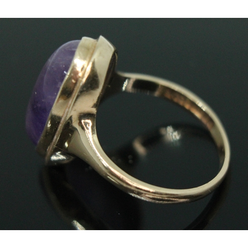 162 - A hallmarked 9ct gold amethyst cabochon ring, the bezel set oval cabochon measuring approx. 19mm x 9... 