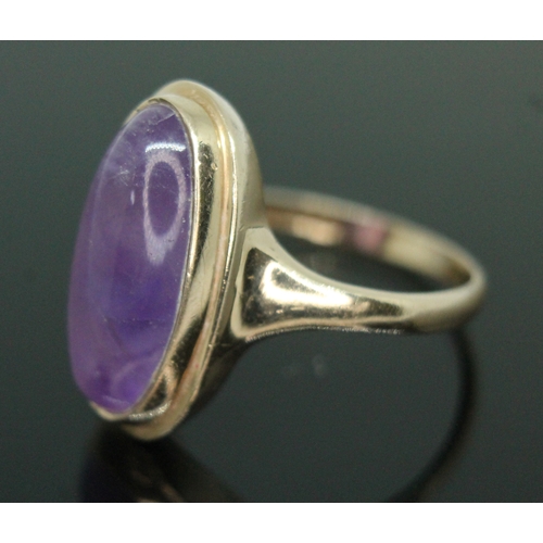 162 - A hallmarked 9ct gold amethyst cabochon ring, the bezel set oval cabochon measuring approx. 19mm x 9... 