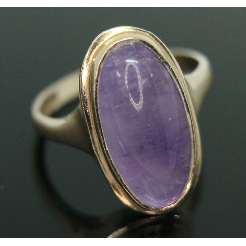 162 - A hallmarked 9ct gold amethyst cabochon ring, the bezel set oval cabochon measuring approx. 19mm x 9... 