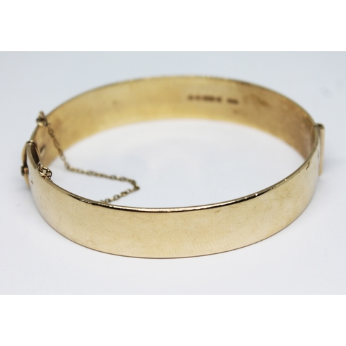 169 - A hallmarked 9ct gold bright cut engraved bangle, diam. approx. 58mm, weight 40.72g.