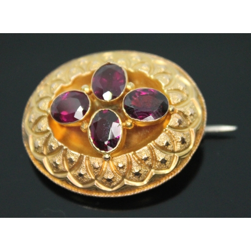 174 - A Victorian yellow metal brooch of oval form and set with four oval cut purple garnets, 36mm x 30mm,... 