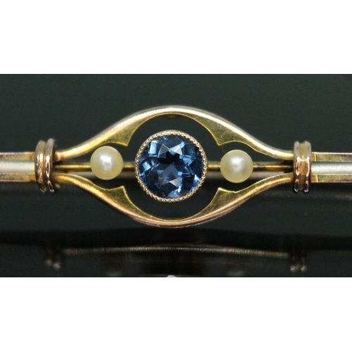 176 - An early 20th century sapphire and seed pearl bar brooch, the central millegrain bezel set round cut... 