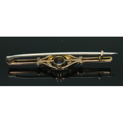 176 - An early 20th century sapphire and seed pearl bar brooch, the central millegrain bezel set round cut... 