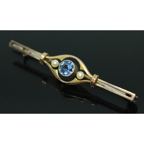 176 - An early 20th century sapphire and seed pearl bar brooch, the central millegrain bezel set round cut... 