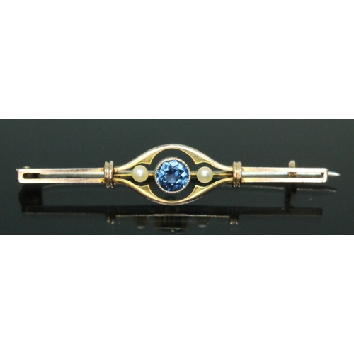 176 - An early 20th century sapphire and seed pearl bar brooch, the central millegrain bezel set round cut... 