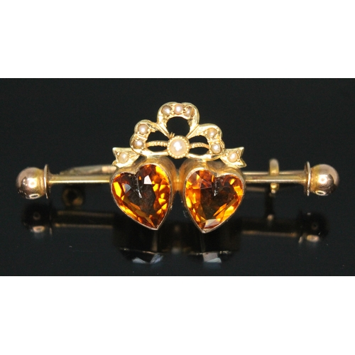 202 - An Edwardian citrine and split pearl brooch, the two heart shaped cut orange citrines measuring appr... 